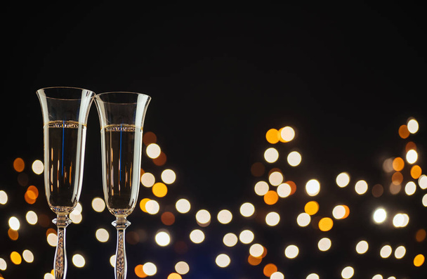 Champagne for festive occasions against a dark background with gold shimmering light and bokeh - Foto, immagini