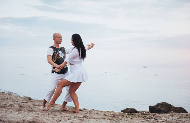 Beautiful inflammatory couple dancing on the beach - Photo, image