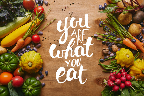 Marco de alimentos saludables verduras y frijoles en la mesa de madera con letras "usted es lo que come"
 - Foto, Imagen