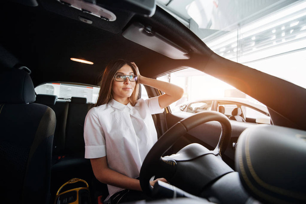 attractive young Caucasian woman looking at the camera from the front seat of the car - Foto, Bild