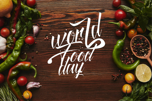 vista dall'alto di verdure fresche e salutari e spezie su sfondo di legno con scritte "world food day"
 - Foto, immagini