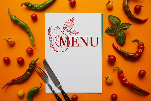 vista superior de cartão com letras "menu" e abacate, talheres e tomates frescos com manjericão e pimentas em laranja
 - Foto, Imagem