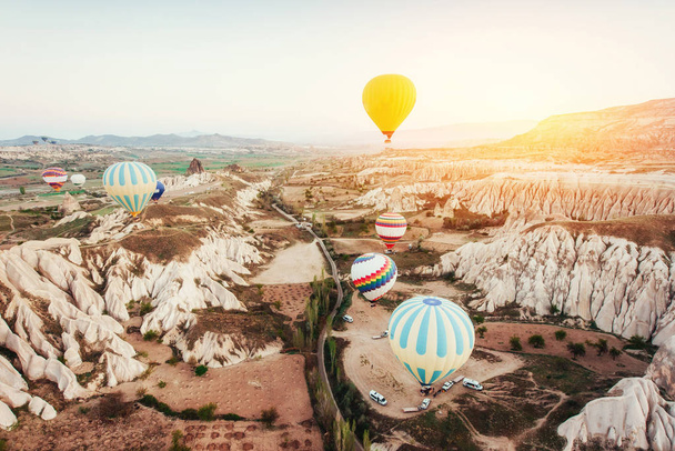 Hot air balloon flying over rock landscape at Turkey. Cappadocia with its valley, ravine, hills, located between the volcanic mountains in Goreme National Park. - Foto, afbeelding
