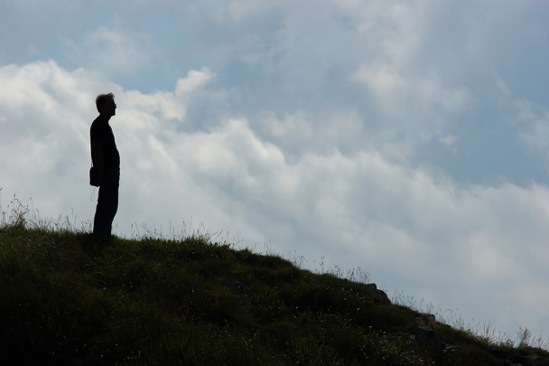 丘の上に立っている男性のシルエット - 写真・画像
