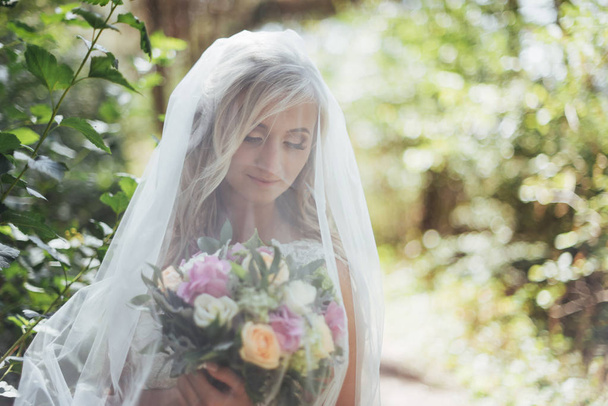 Portrait of a happy bride posing with veil. - Photo, Image