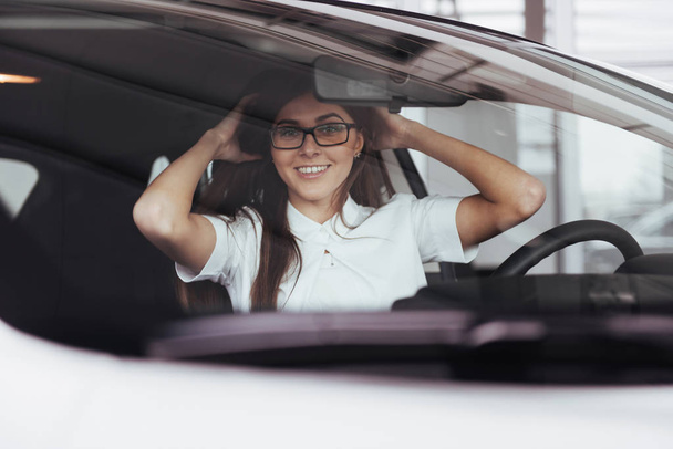 attractive young Caucasian woman looking at the camera from the front seat of the car - Foto, immagini