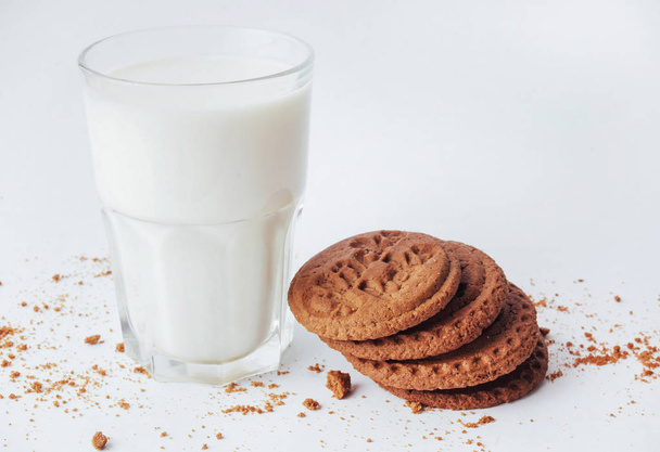 Transparent glass of milk and cookies on a white background. - Photo, image