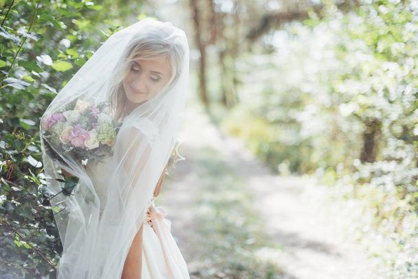 Portrait of a happy bride posing with veil. - Photo, Image
