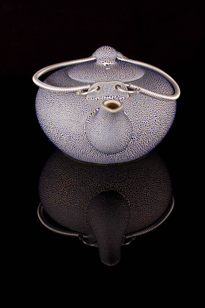 Régi stílusú kávé vagy tea vízforralóval fekete fényvisszaverő felületén - Fotó, kép