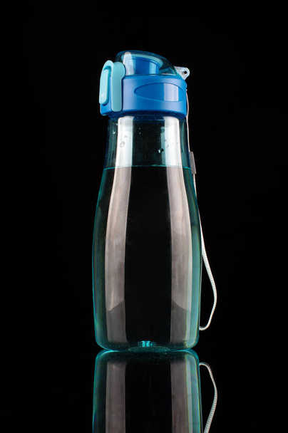 Fitness láhev s vodou izolované na černém pozadí odráží - Fotografie, Obrázek