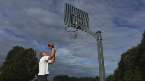 Basketbalový hráč se snaží hodit míč do koše - Záběry, video