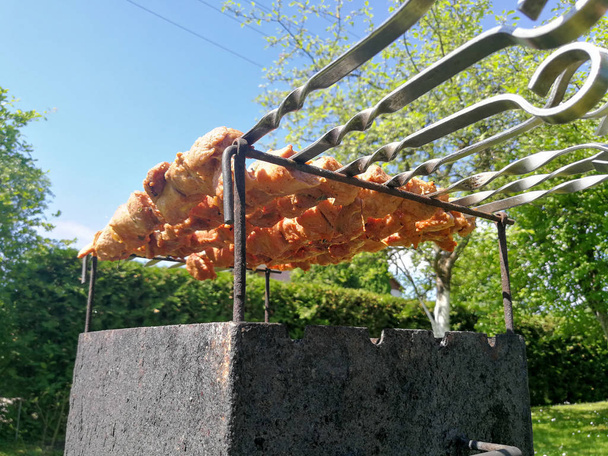 Saslykai of shashlyk op een barbecue-grill grillen op houtskool. Traditionele Litouwse zomer schotel gebruikelijke; ly gegrild in tuinen - Foto, afbeelding