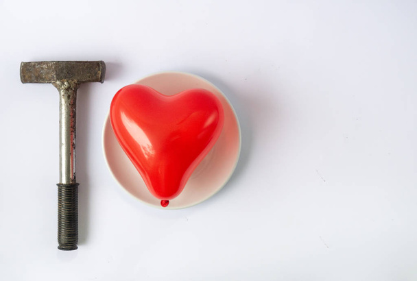 Red heart and hammer. Difficult love and relationship concept. Broken heart, lost love.  - Photo, Image
