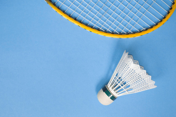 Close up shuttlecock and badminton racket on blue background. - Foto, Imagen