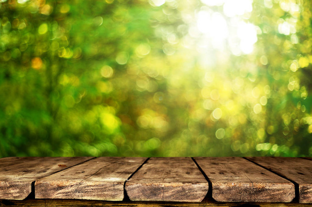 Empty wooden table with blurred natural background - Foto, Imagen
