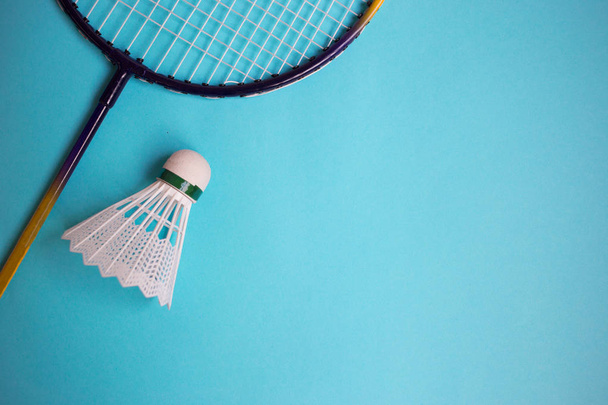 Close up shuttlecock and badminton racket on blue background. - Фото, изображение