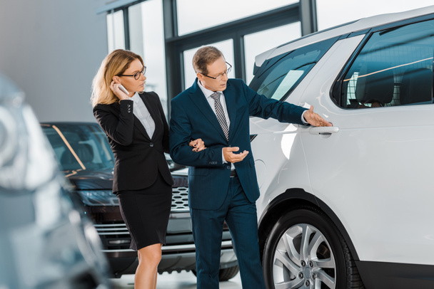 business couple looking for new automobile in dealership salon - Foto, Imagem