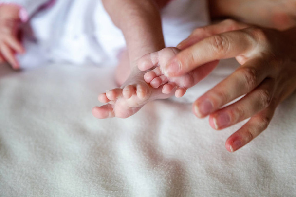 Vauvan jalat äidin käsissä. Pikkuruinen vastasyntyneen vauvan jalat naisen muotoiset kädet lähikuva. Äiti ja hänen lapsensa. Onnellinen perhe käsite. Kaunis käsitteellinen kuva äitiys - Valokuva, kuva