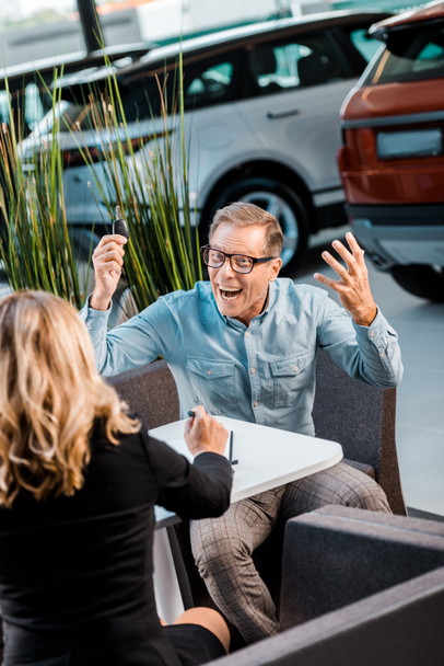 angry adult man shouting at female car dealer in salon - Foto, Imagem