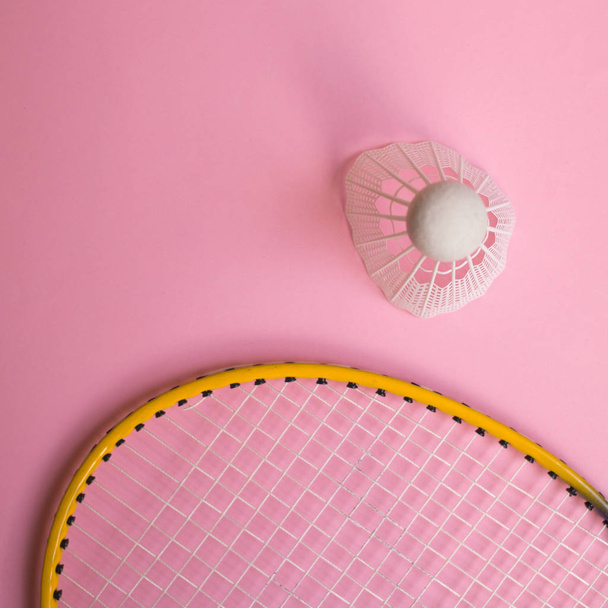 Close up shuttlecock and badminton racket on pinl background. - Фото, изображение