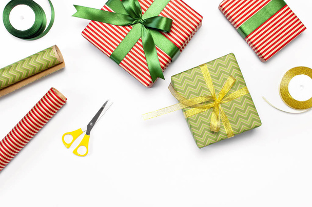 Coffrets cadeaux, papier d'emballage, ciseaux, ruban sur fond blanc. Fête arrière-plan, félicitations, emballage cadeau, Noël et le thème du Nouvel An. Couché plat, vue du dessus
 - Photo, image