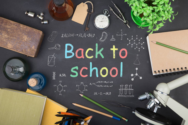 Education concept - books, microscope and Back to school inscription on the blackboard - Foto, Imagen