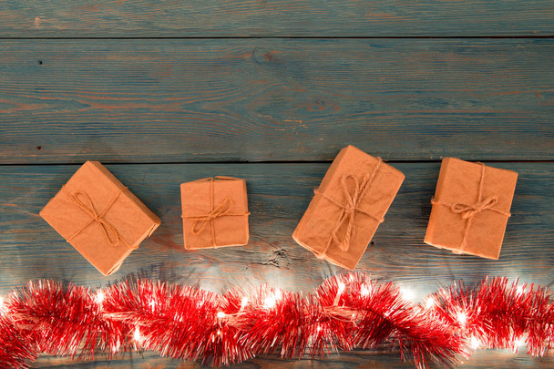 Christmas gifts and lights on the wooden background - Photo, Image