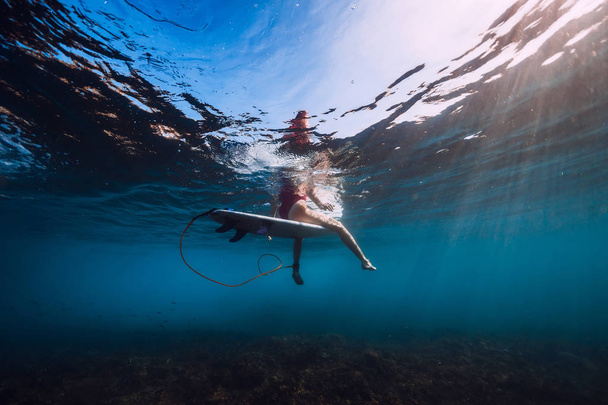 Surf woman sit at surfboard, Underwater view of surfer in ocean - Photo, Image