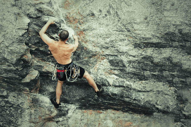 Atleta escalador escalando un acantilado sin equipo de escalada, espacio de copia
 - Foto, imagen