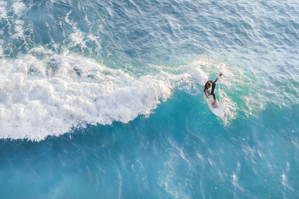 Surfer at the top of the wave in the ocean, top view - Fotoğraf, Görsel