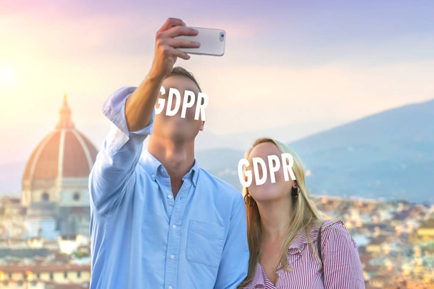 Egy fiatal pár, a turisták selfie fénykép smartphone és az arcukat, hogy eltakarja a felirat Gdpr. adatvédelmi rendeletben. Számítógépes biztonság és adatvédelem. - Fotó, kép