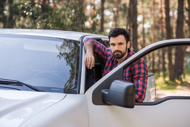 bearded driver standing at pickup truck in forest - Fotoğraf, Görsel