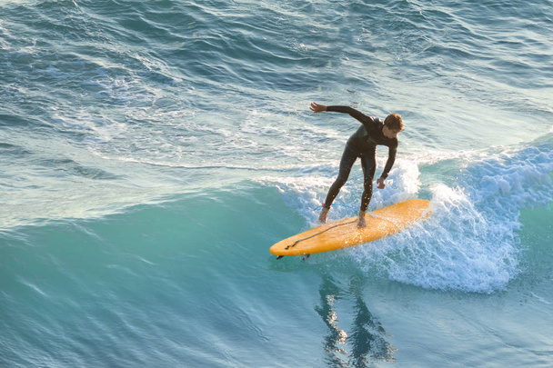 Bogliasco, Italy, October 6, 2017:  Surfer on a yellow surfboard riding a wave - Fotoğraf, Görsel