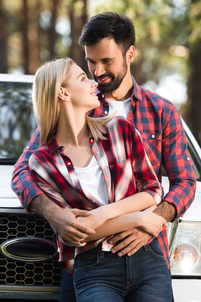 νεαρό ζευγάρι αγκαλιάζει κάθε άλλο κοντά σήκωσε αυτοκινήτου σε εξωτερικούς χώρους  - Φωτογραφία, εικόνα