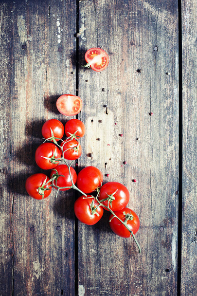 Appetizing branch of tomatoes on wooden table - Fotoğraf, Görsel