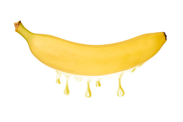 Ripe banana fruit with a juice dropping from it, isolated on white background. - 写真・画像