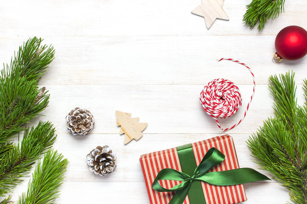 Vánoční složení. Nový rok dřevěné hračky, dárkové, jedle kavkazská, borové větve, červený míč, dar vlákna na bílý dřevěný stůl s plochou ležela pohled shora kopie prostor. Vánoční Zimní dekorace příroda nový rok koncepce - Fotografie, Obrázek