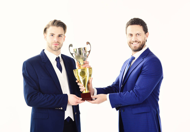 Business victory, support, partership concept. Businessman with confedent face receives prize. Awarded worker smiles and receives trophy on white background. Partners celebrate victory togethe - Photo, image