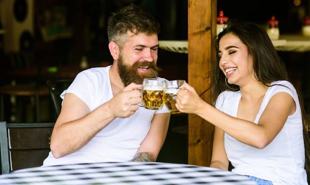 Couple in love on date drinks beer. Best friends or lover drinking in pub. Couple brutal date at pub. Man bearded hipster and girl with beer glass full of craft beer. Friendly meeting just drink beer - Foto, Imagen