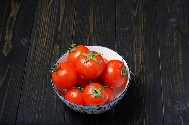 Ripe, fresh tomatoes on dark rustic wooden background. Organic, healthy, raw, vegetarian food. - 写真・画像