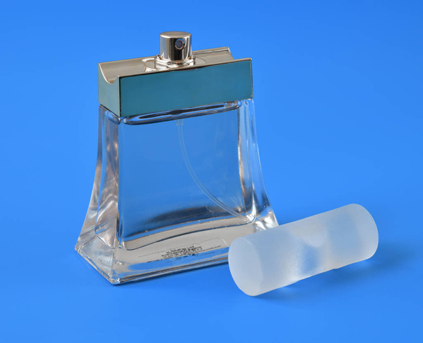 transparent bottle with toilet water on a blue background - Fotografie, Obrázek