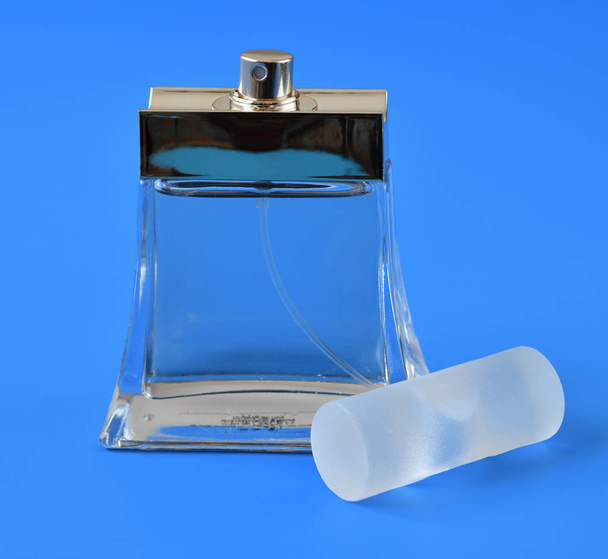 transparent bottle with toilet water on a blue background - Fotografie, Obrázek