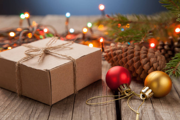 Christmas gift box and garland on wooden table - Φωτογραφία, εικόνα