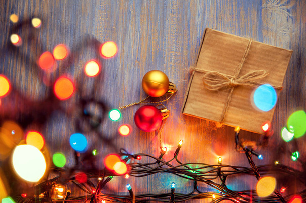 vista superior de la caja de regalo de Navidad y decoraciones de iluminación sobre fondo de madera
 - Foto, imagen
