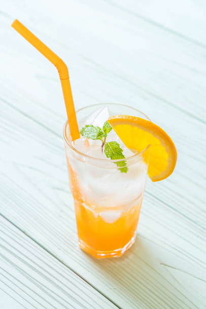 orange juice with soda on wood table - Фото, зображення