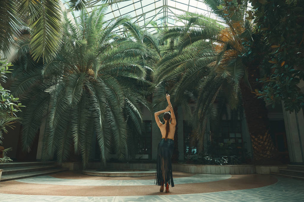 Tánc az életmód fogalmát. Fiatal gyönyörű nő táncosokról egy csodálatos trópusi kert és pálmafák a háttérben egy üveg rooftop. Szenvedély, a motiváció és az inspiráció. - Fotó, kép