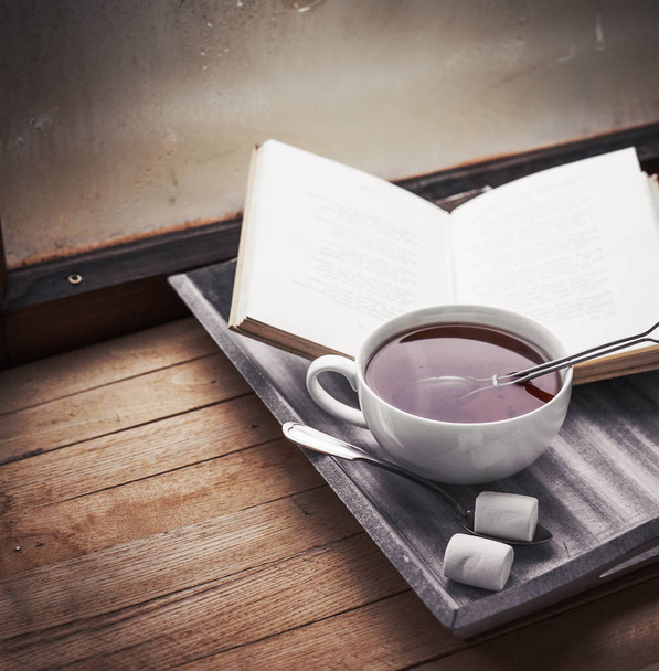 vista de primer plano de la taza de té fresco con libro sobre mesa de madera
 - Foto, Imagen
