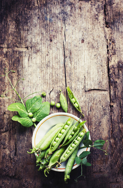 bowl with green peas on wooden background - Фото, зображення