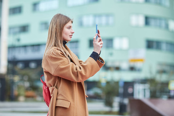 Una ragazza scatta una foto nel centro della città. Ragazza che fa foto sul tuo telefono. centro di Mosca
.  - Foto, immagini