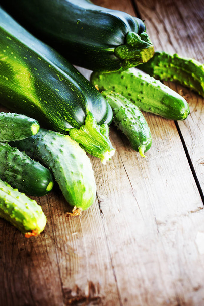 closeup view of zucchini and cucumbers over wooden background - Zdjęcie, obraz
